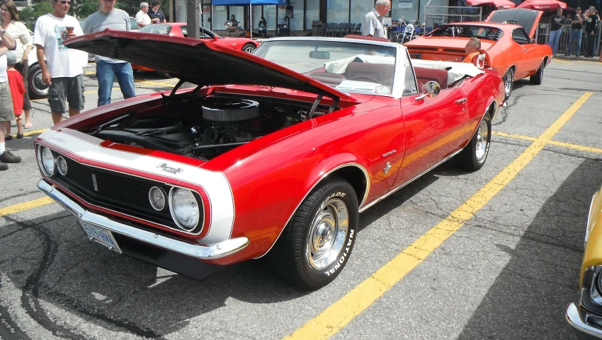 a red car parked in a parking lot next to other cars