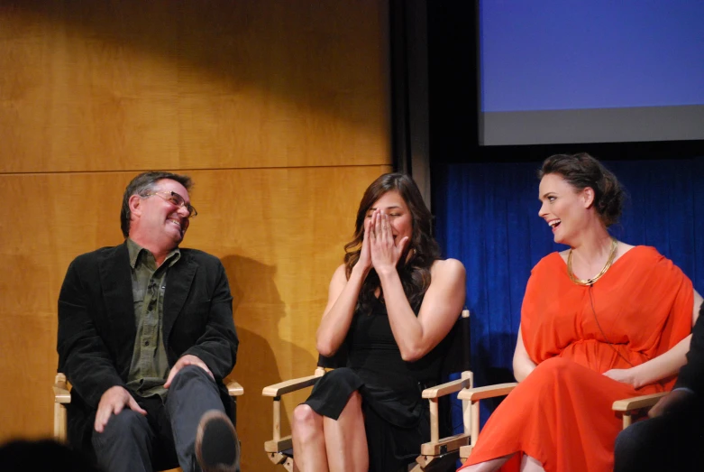 two people sitting on chairs next to each other