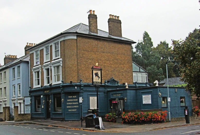 people standing outside of an old blue building