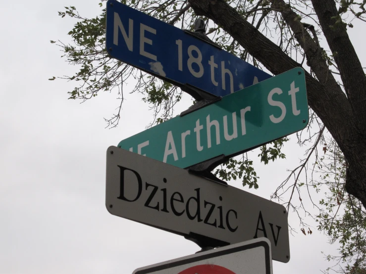 four street signs in two different languages on top of each other