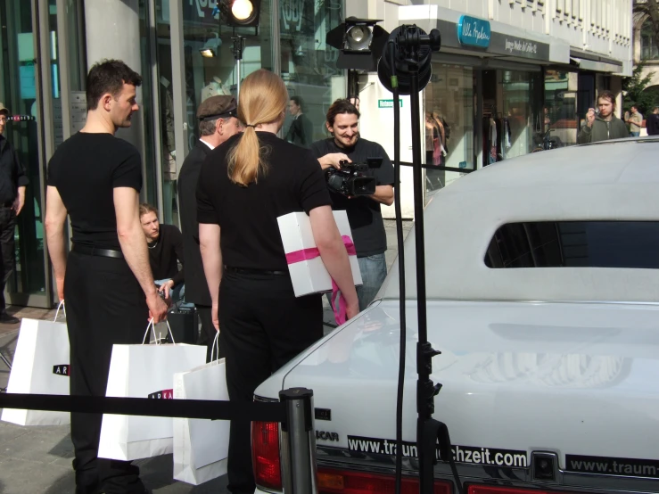 people gathered around while there is a woman getting into a car