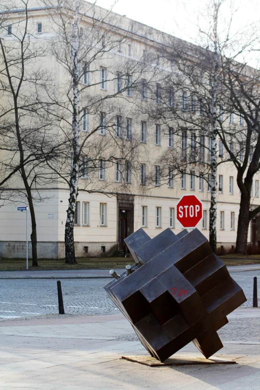 a stop sign with a giant brown sculpture in front of a building