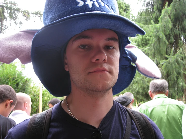 a man wearing a blue hat with a blue ribbon around it