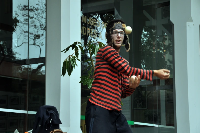 a man throwing a tennis ball in front of a house