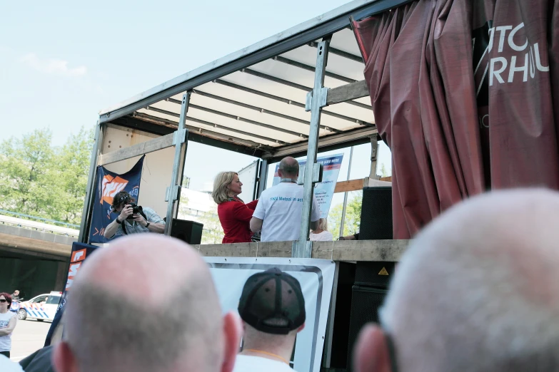 two people stand on top of a stage in front of a crowd