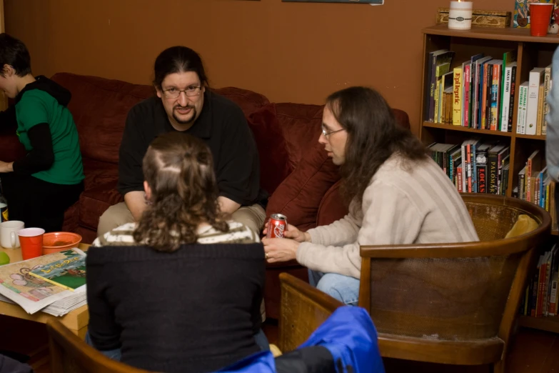 a group of people sit in chairs at a table with a coffee mug