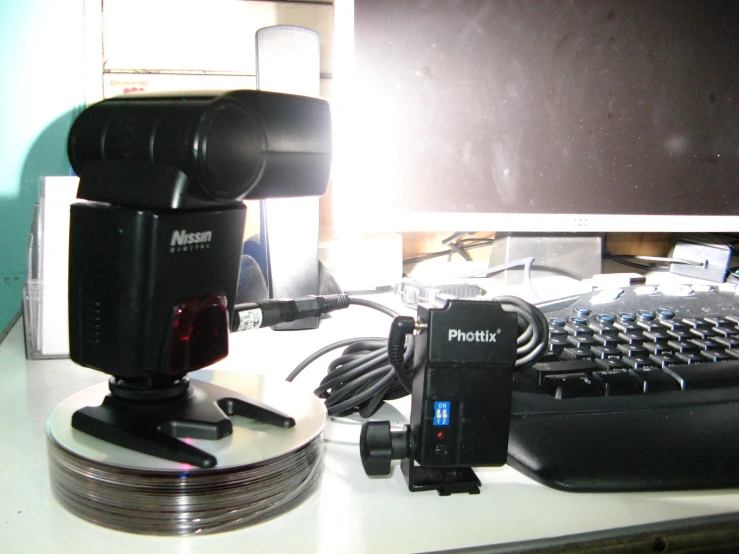 a cell phone, mouse, keyboard and tripod sitting on a desk