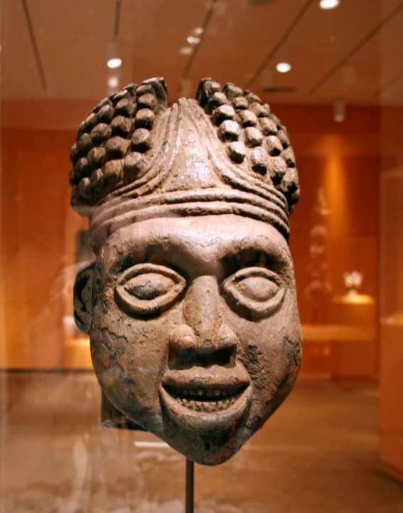 an ancient stone head sitting in a museum