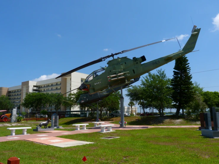 an army helicopter is parked in a green area