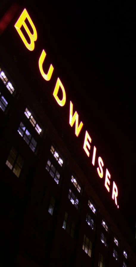 building at night lit up with neon lettering that says pfm