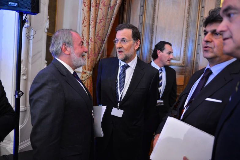 three men in business suits talking and posing