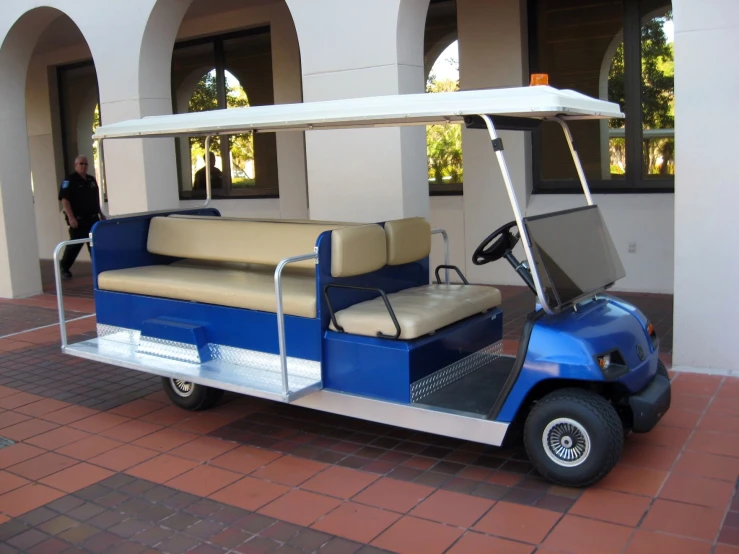 a blue golf cart with two seats, and a coach