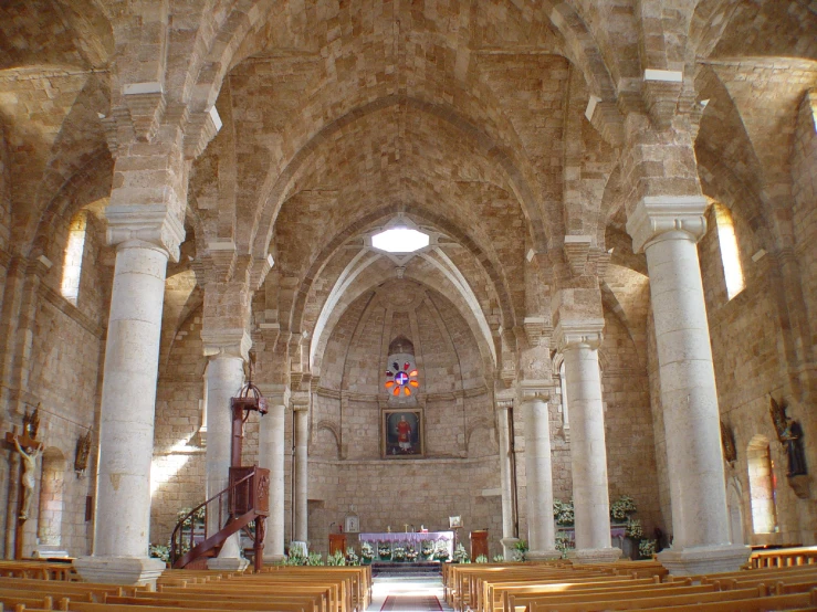 the interior of a cathedral with wooden pews