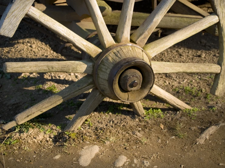 the spokes and axles of an old cart or wagon wheel