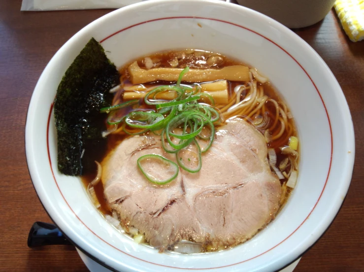 a bowl filled with noodles, meat and vegetables