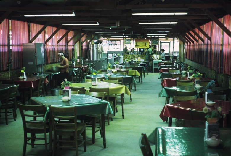 a diner sitting down to some tables with lots of chairs