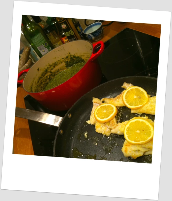 a pan of food with some slices of lemon on top