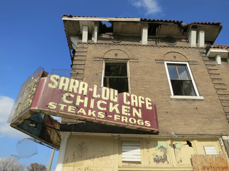 a sign for an old restaurant in front of an old brick building