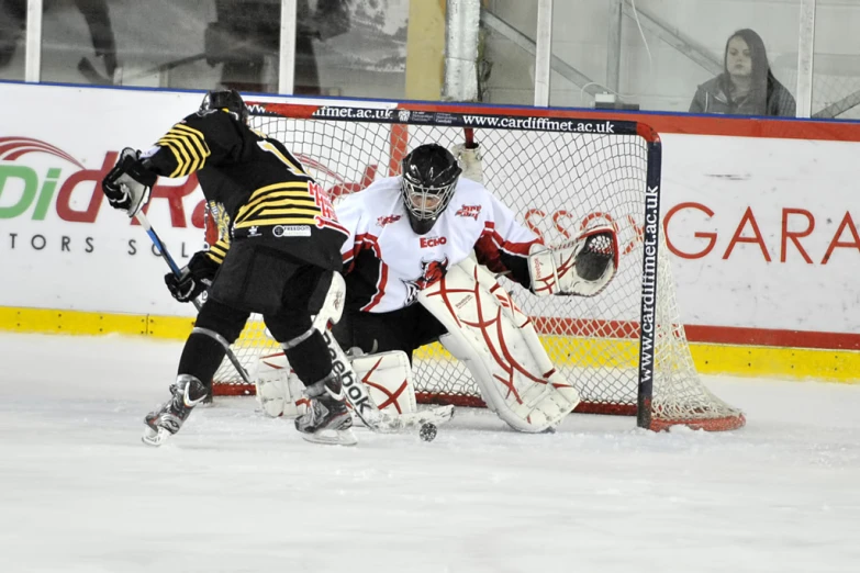 two men play hockey against each other on the ice