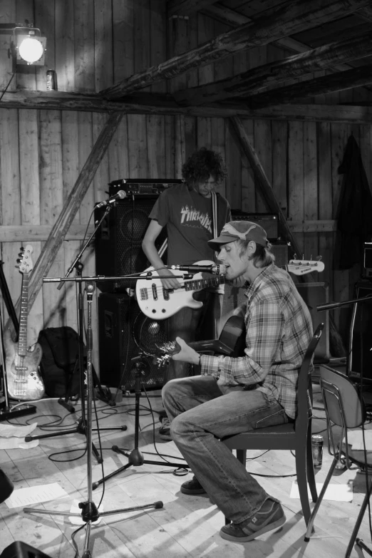 some people playing instruments and guitars inside a barn