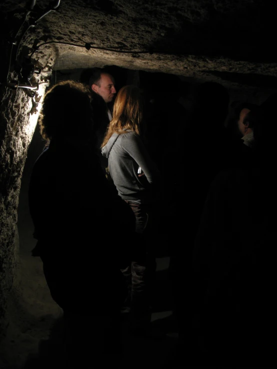 a group of people stand around in a cave