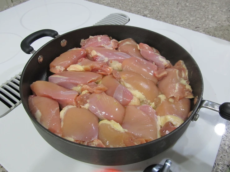 meat that is cooking in a pan on the stove