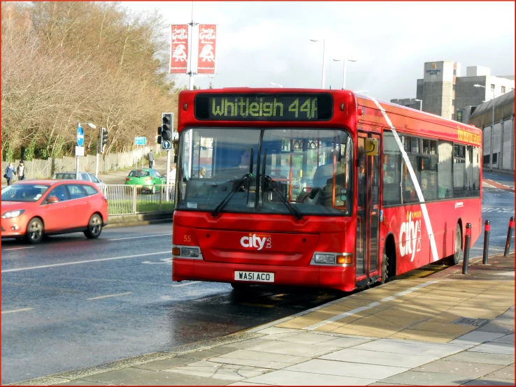 a passenger bus going down a street, at a stoplight