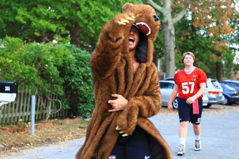 man in a bear costume is being chased by a 