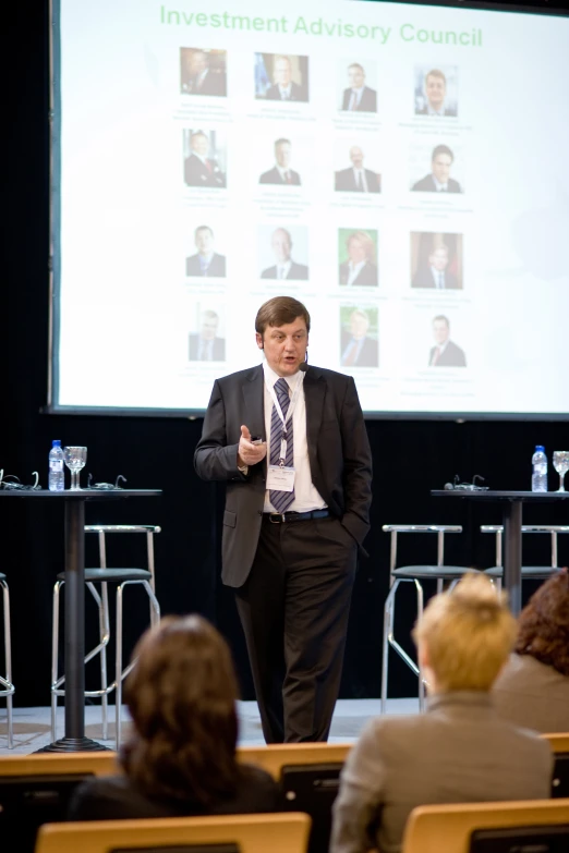 a man in a business suit standing in front of a crowd