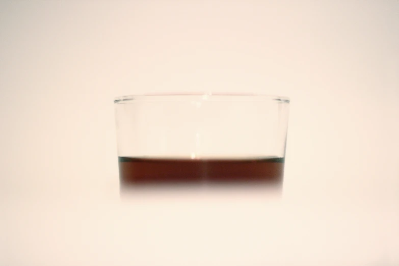 a glass filled with liquid sitting on top of a counter