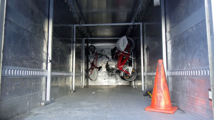 two bicycles sitting in a trailer next to traffic cones