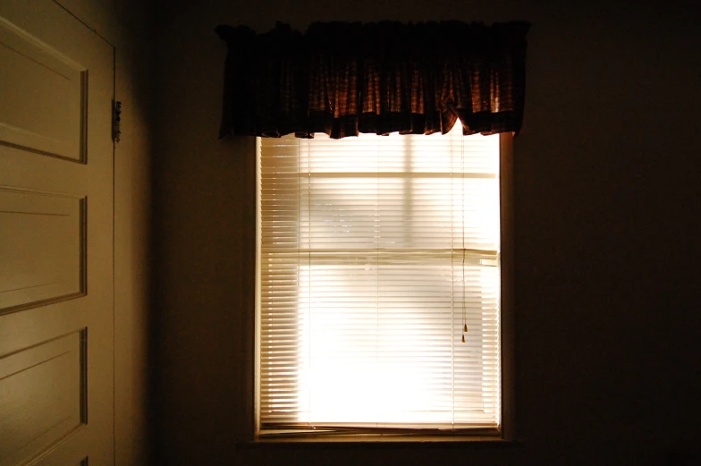 a small window is covered by a black sheer