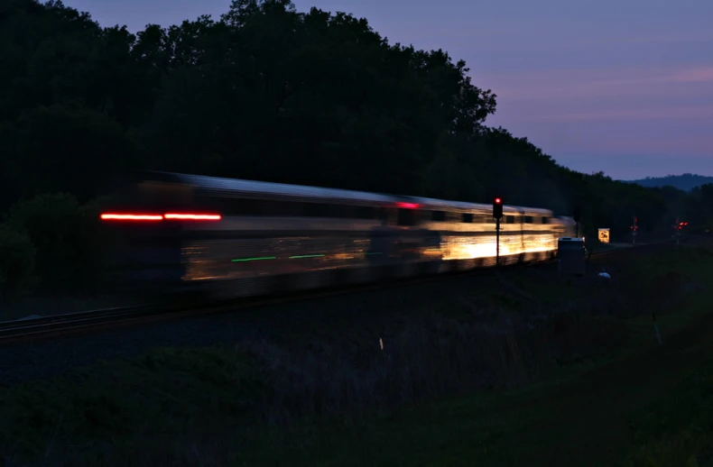 a train travels at dusk on the tracks