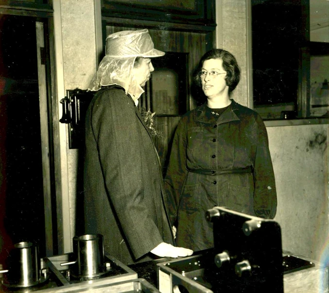 a man and woman standing in front of a oven