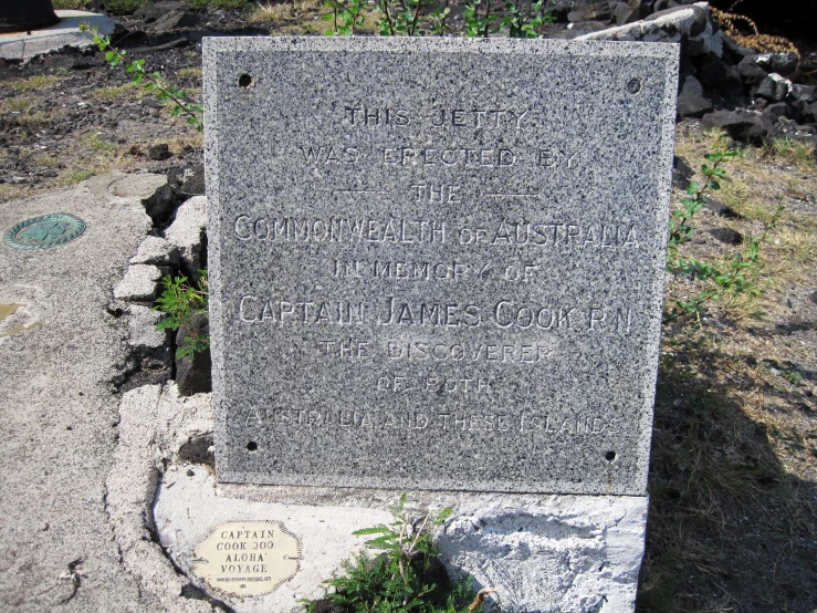 a plaque sitting on top of a rock covered park