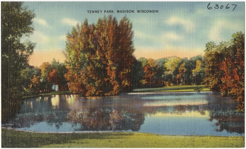 a large, tree - lined lake surrounded by mountains