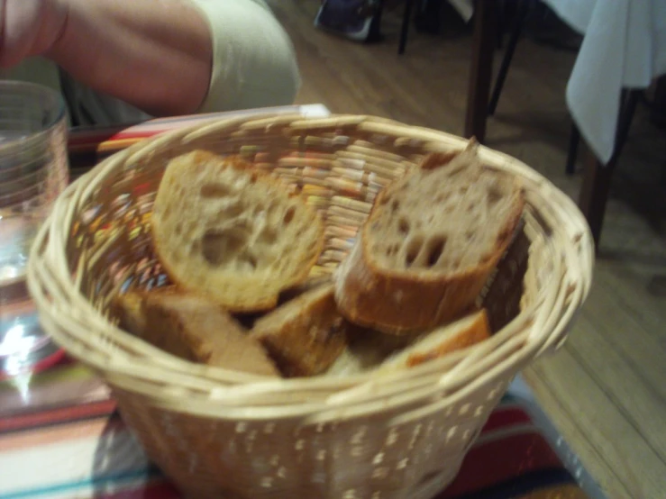 a wooden basket containing some bread slices on a table