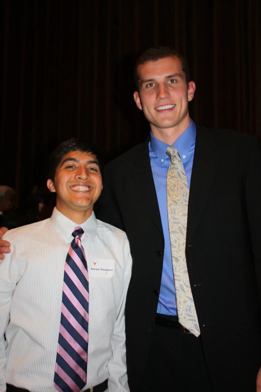 two people with ties that are standing together