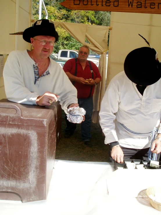 a man wearing a hat, holding out food