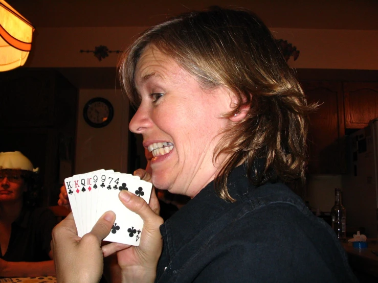 the woman is holding up cards in both hands