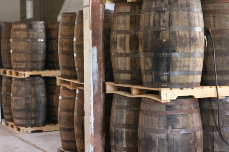 old oak barrels are stacked on shelves for storage