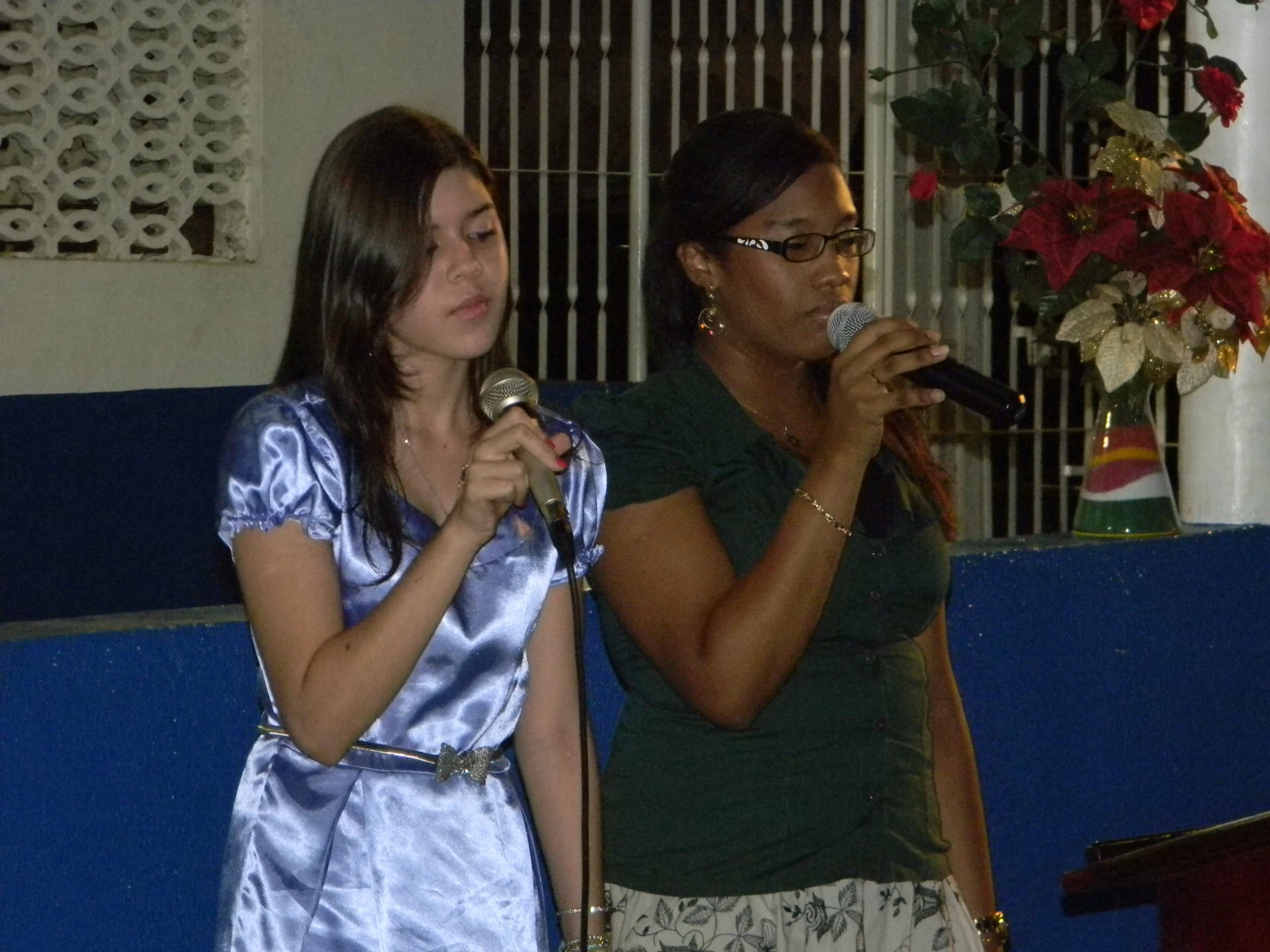 a woman is holding a microphone and standing in front of a woman