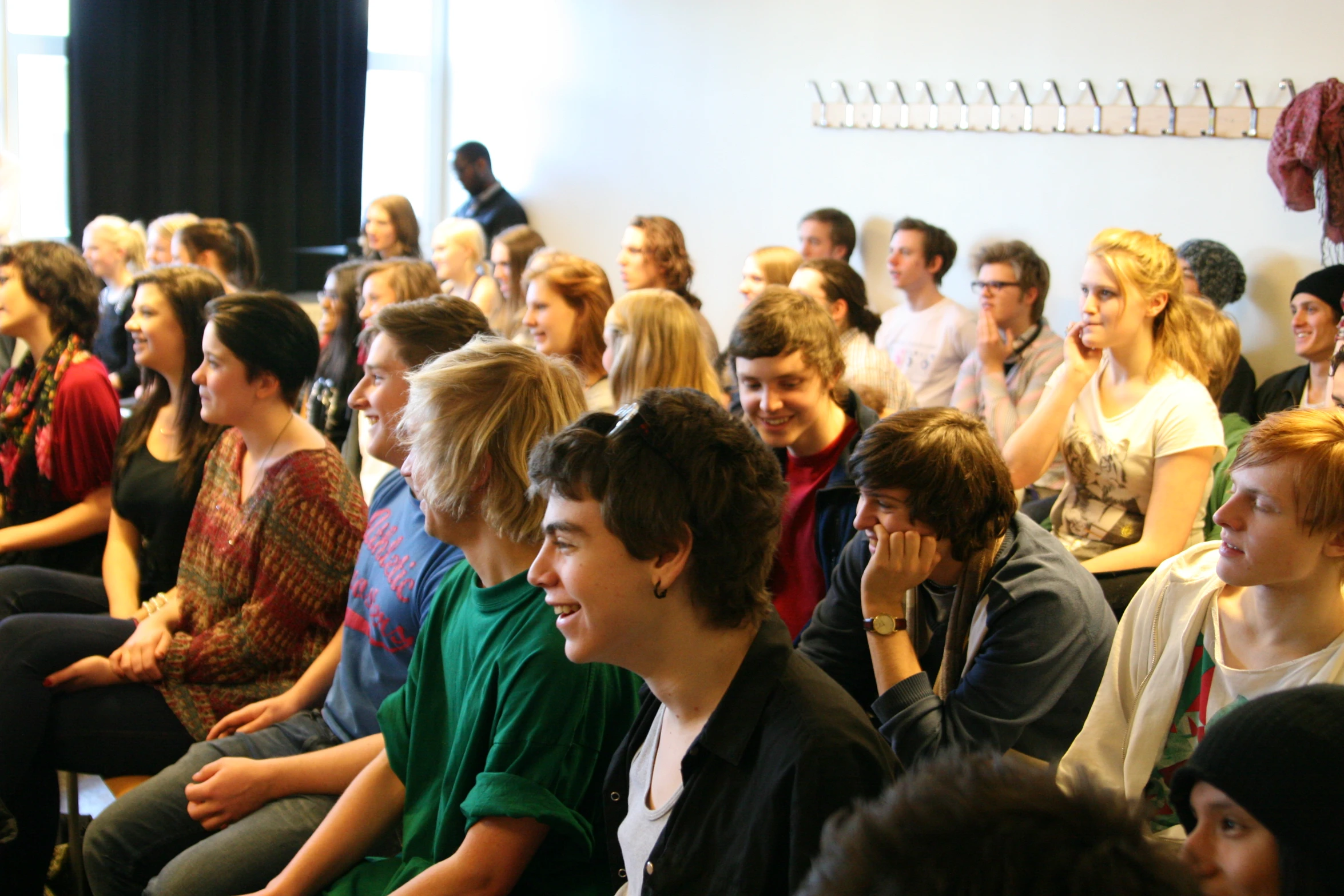 large group of people seated and waiting in a room