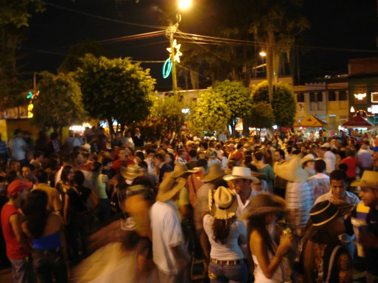 many people stand in a crowd during a festival