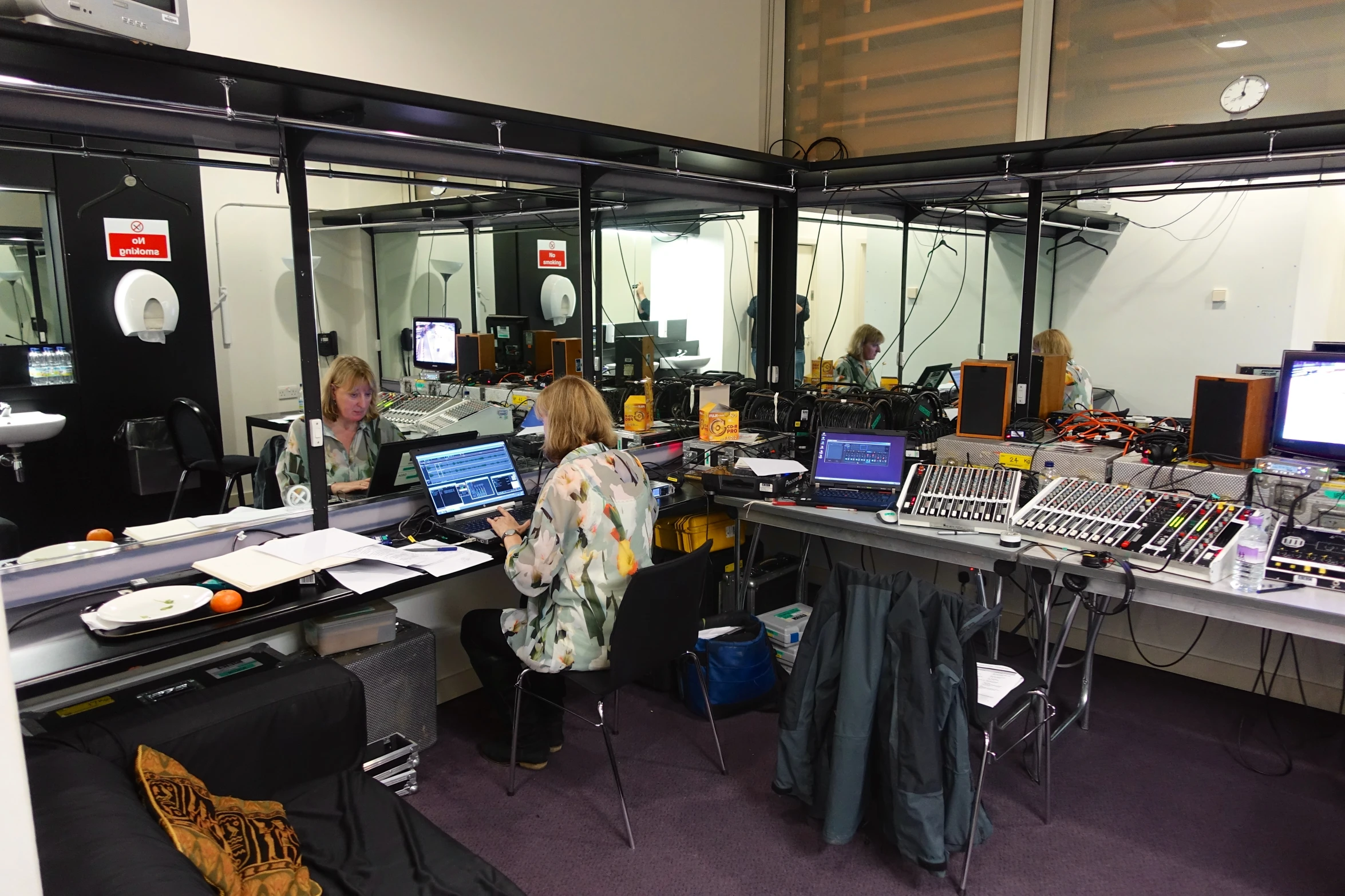 people sitting at computers in a room with mirrors