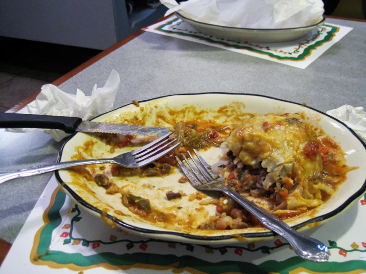 a white plate filled with meat and cheese covered lasagna