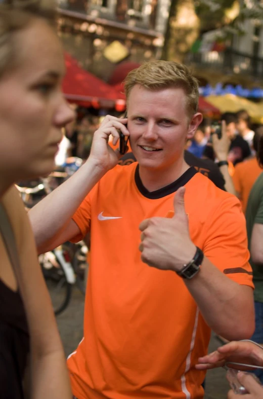 a man gives thumbs up as he talks on a cellphone
