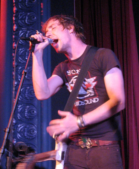 a man standing in front of a microphone with his mouth open