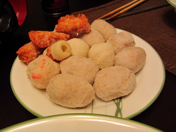 a plate topped with some little donuts and fried vegetables