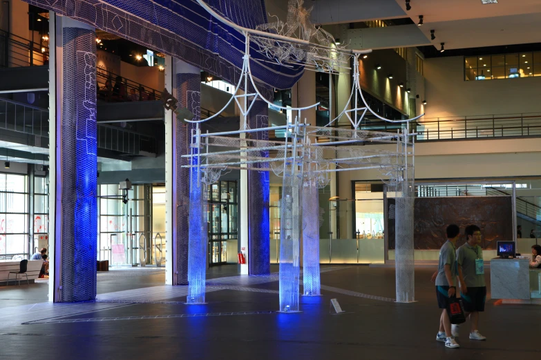 two people are walking towards a beautiful building with glass pillars